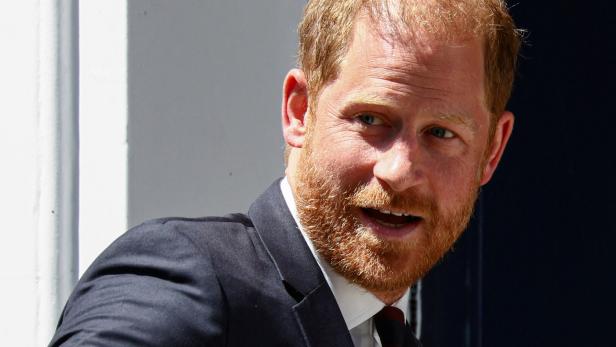Prinz Harry mit Vollbart und im Anzug blickt zur Seite.